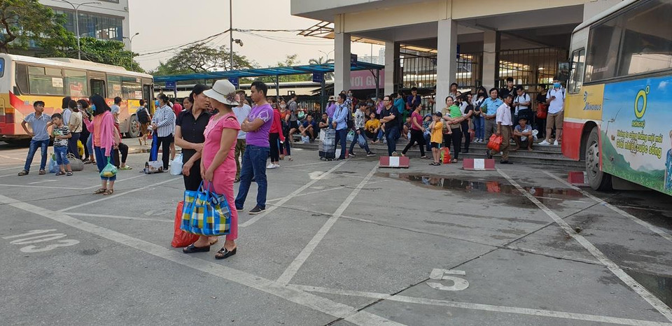 Hành khách ngồi la liệt chờ xe buýt vào bến xe. (Ảnh: Việt Hùng/Vietnam+)