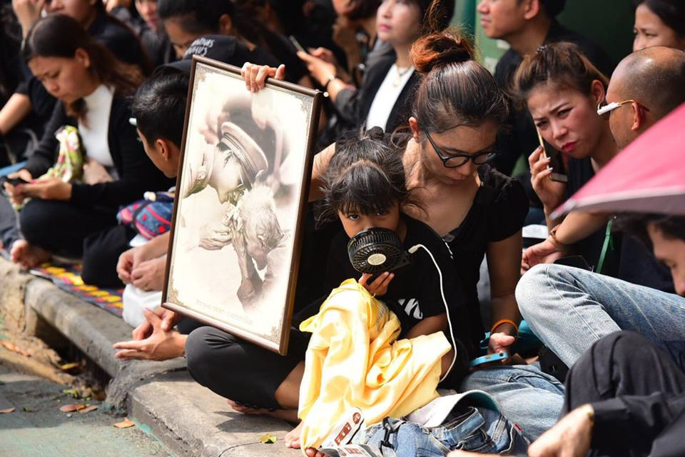 Người dân Thái Lan cầm ảnh Nhà vua Bhumibol Adulyadej để thể hiện sự thành kính. (Nguồn: Channel NewsAsia)