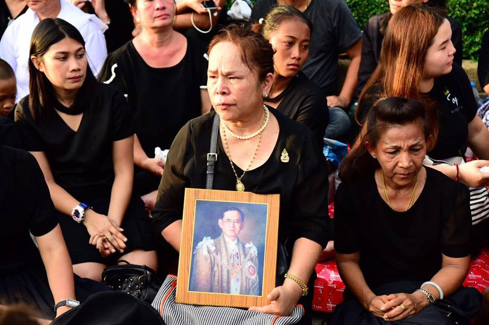 Người dân Thái Lan cầm ảnh Nhà vua Bhumibol Adulyadej để thể hiện sự thành kính. (Nguồn: Channel NewsAsia)