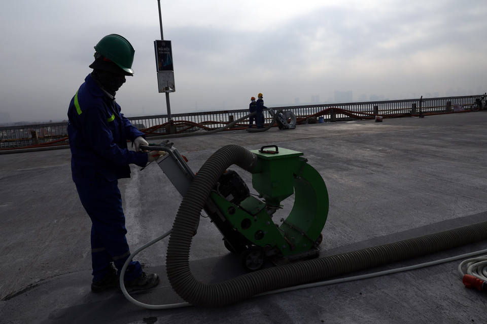 Từ nay đến cuối năm 2020, các đơn vị thi công sẽ tạo nhám, quét keo Epoxy dính bám và thi công lớp phủ mặt cầu. (Ảnh: Huy Hùng/TTXVN)