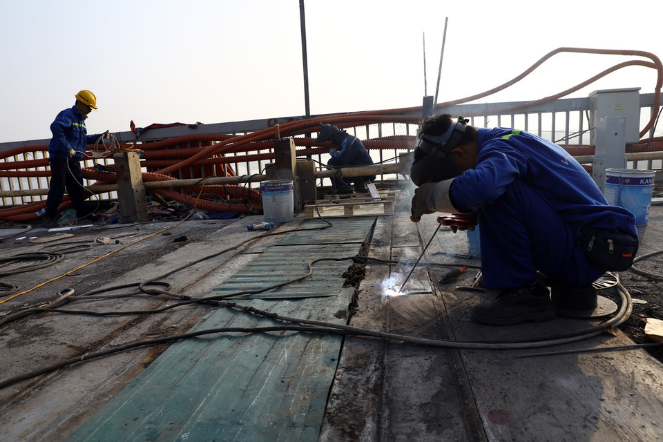 Thi công khe co giãn mặt cầu Thăng Long. (Ảnh: Huy Hùng/TTXVN)