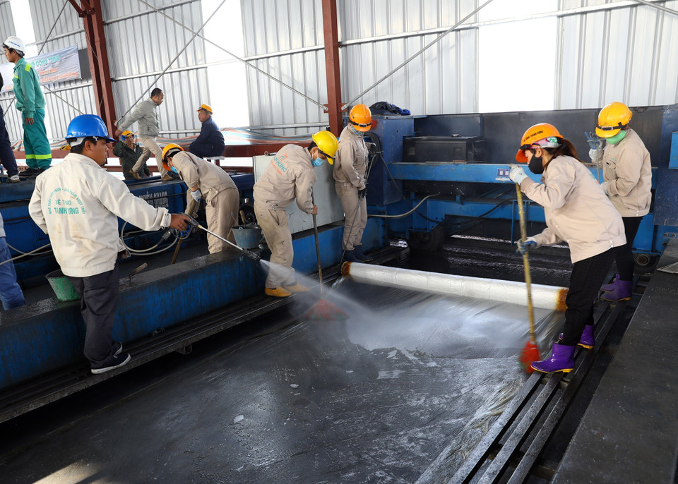 Thi công lớp phủ mặt cầu. (Ảnh: Huy Hùng/TTXVN)