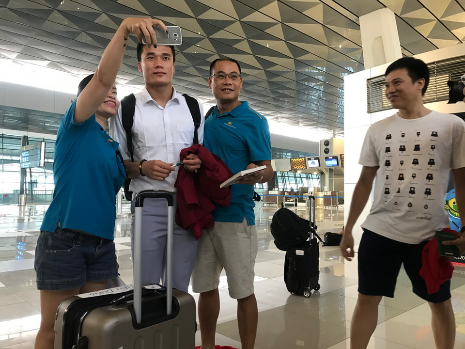 Người hâm mộ chụp ảnh lưu niệm và xin chữ ký các cầu thủ tại sân bay Quốc tế Soekarno-Hatta (Indonesia). (Ảnh: TTXVN) 