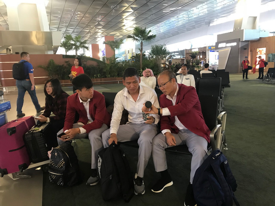 Huấn luyện viên Park Hang Seo rót nước cho cầu thủ tại sân bay. (Ảnh: Đỗ Quyên/Vietnam+)