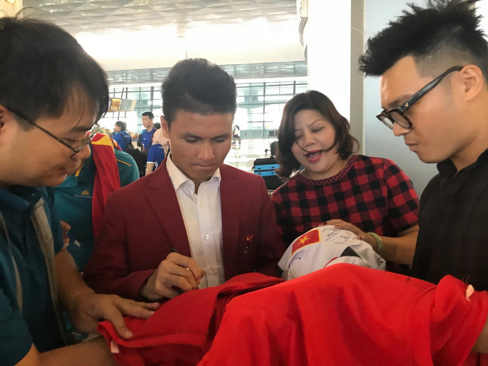 Người hâm mộ chụp ảnh lưu niệm và xin chữ ký cầu thủ Quang Hải tại sân bay Quốc tế Soekarno-Hatta (Indonesia). (Ảnh: Đỗ Quyên/Vietnam+)