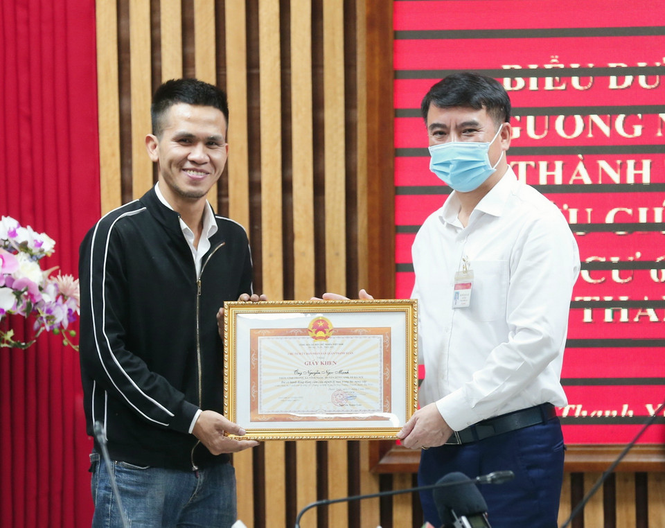 Ông Nguyễn Xuân Lưu, Bí thư Quận uỷ, Chủ tịch UBND quận Thanh Xuân tặng Giấy khen biểu dương tài xế xe tải Nguyễn Ngọc Mạnh (31 tuổi, quê ở huyện Đông Anh). (Ảnh: Doãn Tấn/TXVN)