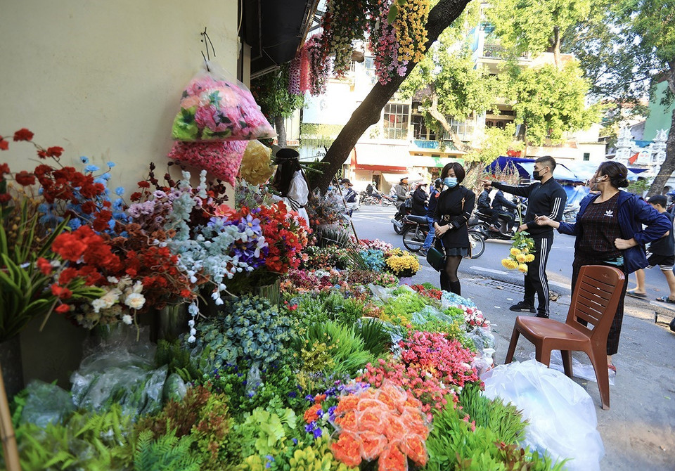 Một cửa hàng trên phố Hàng Chai bán cây, hoa giả với nhiều mẫu mã, màu sắc thu hút nhiều người dân đến mua sắm. (Ảnh: Hoàng Hiếu/TTXVN)