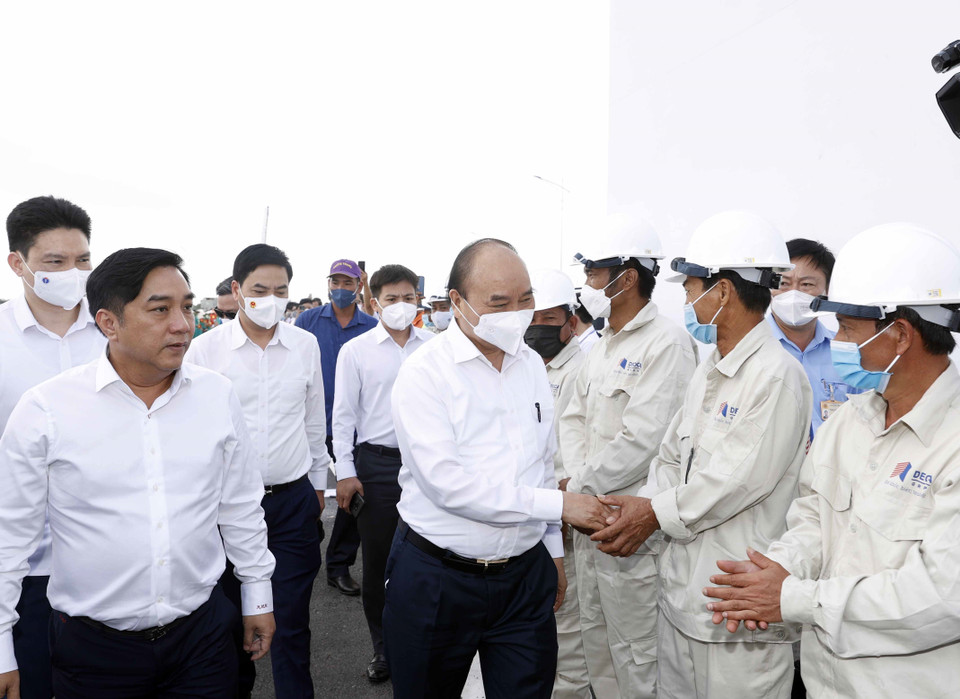 Chủ tịch nước Nguyễn Xuân Phúc thăm hỏi, động viên các kỹ sư, công nhân tham gia thi công Dự án tuyến đường cao tốc Trung Lương-Mỹ Thuận. (Ảnh: Thống Nhất/TTXVN)