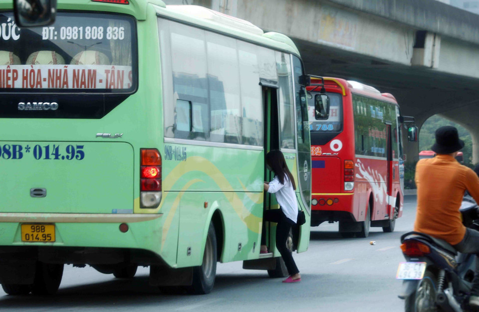 Xe khách dừng, đỗ đón trả khách sai quy định trên tuyến đường Phạm Hùng. (Ảnh: Phạm Kiên/TTXVN)