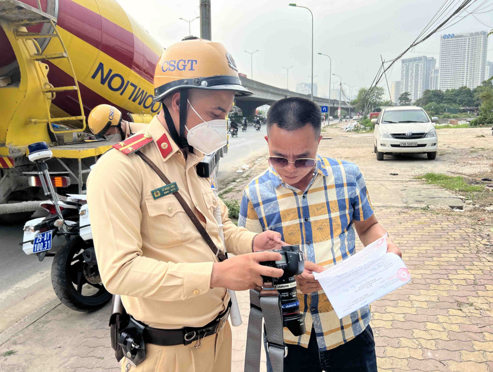 Nhiều lái xe sau khi bị dừng kiểm tra đã không nhận mình mắc lỗi. Tuy nhiên, khi được cho xem hình ảnh thực tế đã phải ký vào biên bản xử phạt. (Ảnh: Phạm Kiên/TTXVN)
