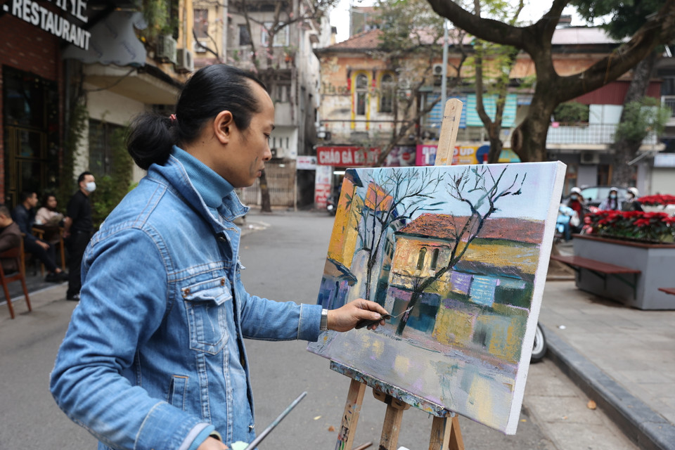 Hoạ sỹ đang vẽ lại khung cảnh êm đềm của ngôi nhà trên phố cổ. (Ảnh: Minh Hiếu/Vietnam+)