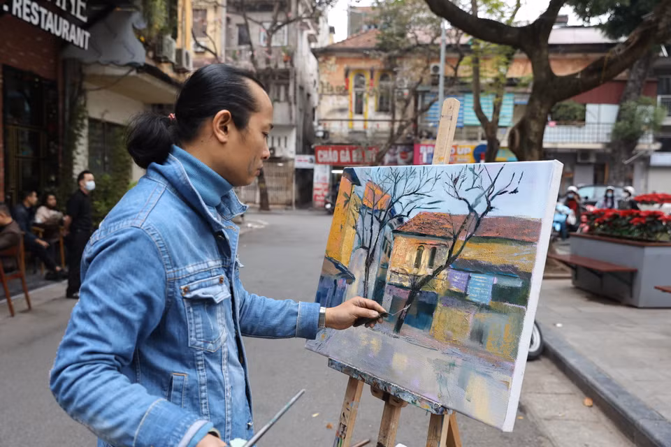 Hoạ sỹ đang vẽ lại khung cảnh êm đềm của ngôi nhà trên phố cổ. (Ảnh: Minh Hiếu/Vietnam+)