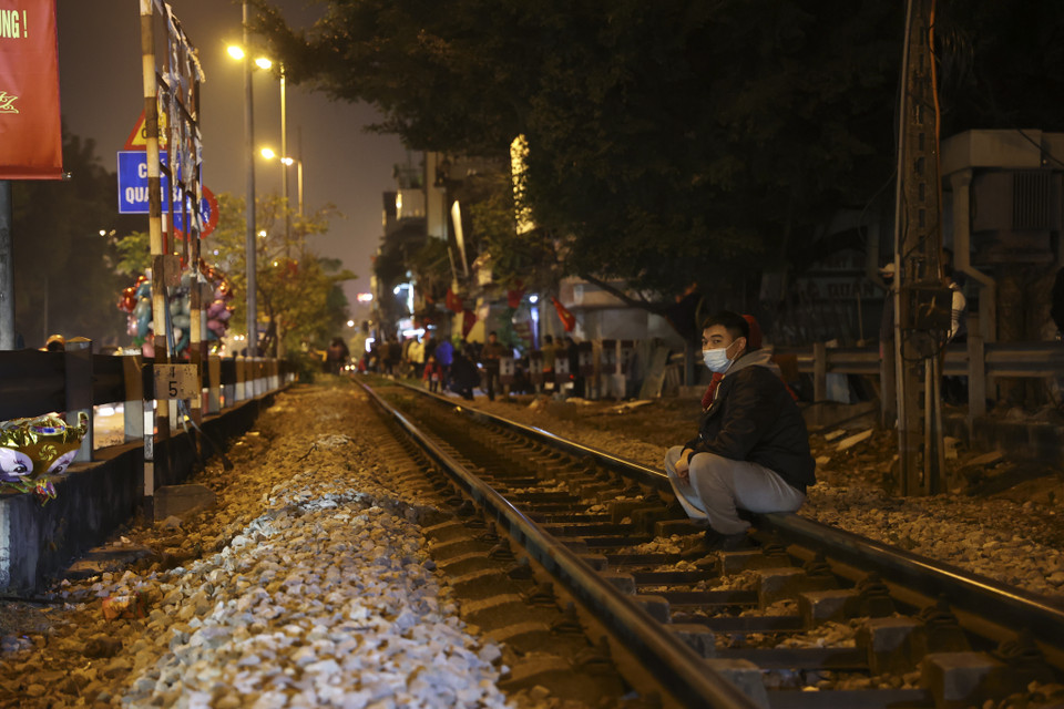 Nhiều người tân tụ tập quanh khu vực đường ray tàu hoả tiềm ẩn nguy hiểm. (Ảnh: Minh Hiếu/Vietnam+)