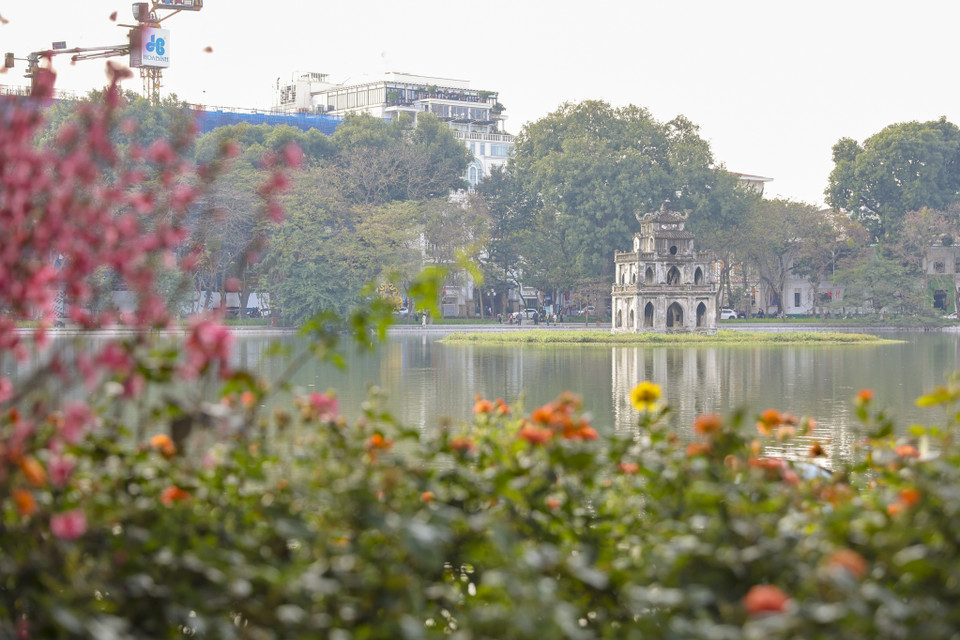 Hồ Gươm như khoác thêm tấm áo rực rỡ với những sắc hoa muôn màu. (Ảnh: Minh Hiếu/Vietnam+)