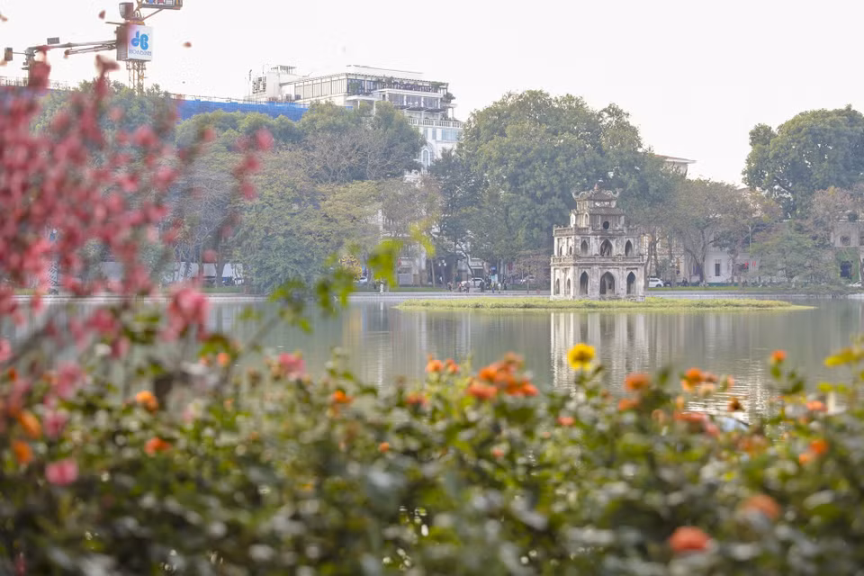 Hồ Gươm như khoác thêm tấm áo rực rỡ với những sắc hoa muôn màu. (Ảnh: Minh Hiếu/Vietnam+)