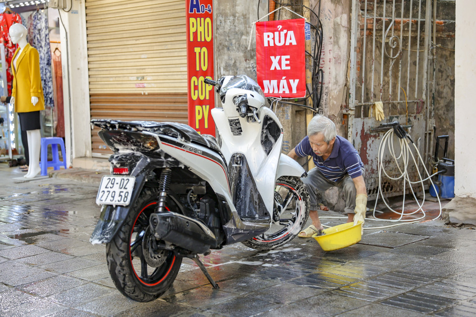 Rửa xe là nghề 'hốt bạc' trong những ngày cận Tết. (Ảnh: Minh Hiếu/Vietnam+)