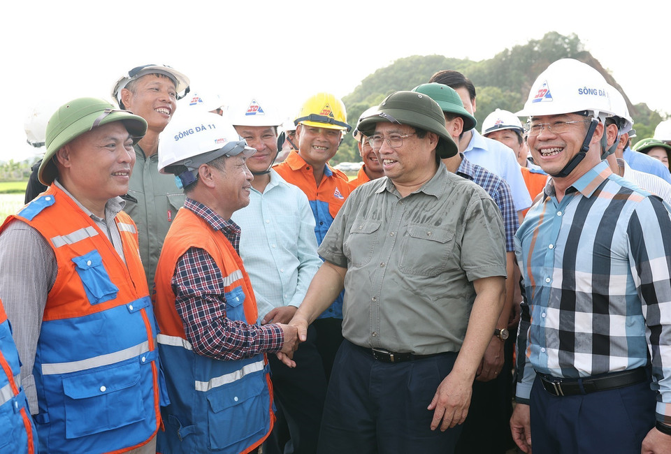 Thủ tướng Phạm Minh Chính thăm, động viên công nhân thi công kéo dây khoảng néo 109-117 tại xã Cầu Lộc, huyện Hậu Lộc, tỉnh Thanh Hóa. (Ảnh: Dương Giang/TTXVN)