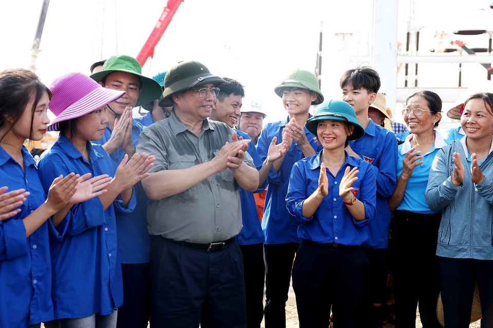 Thủ tướng Phạm Minh Chính động viên thanh niên trên công trường Dự án Trạm biến áp 500 kV Thanh Hóa tại xã Thiệu Phúc, huyện Thiệu Hóa, tỉnh Thanh Hóa. (Ảnh: Dương Giang/TTXVN)