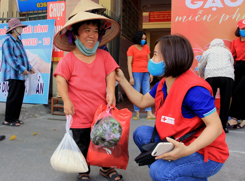 Cấp phát gạo miễn phí cho người nghèo, người khuyết tật, người bị mất việc làm do ảnh hưởng của dịch Covid-19 địa chỉ số 237, đường Hai Bà Trưng, phường Đề Thám, thành phố Thái Bình do Hội Chữ thập Đỏ tỉnh Thái Bình phối hợp với Công ty Cổ phần sách Thái Hà, Câu lạc bộ kết nối muôn phương Thái Bình và Nhóm không gian đọc Chia sẻ và kết nối tổ chức. (Ảnh: Thế Duyệt/TTXVN)