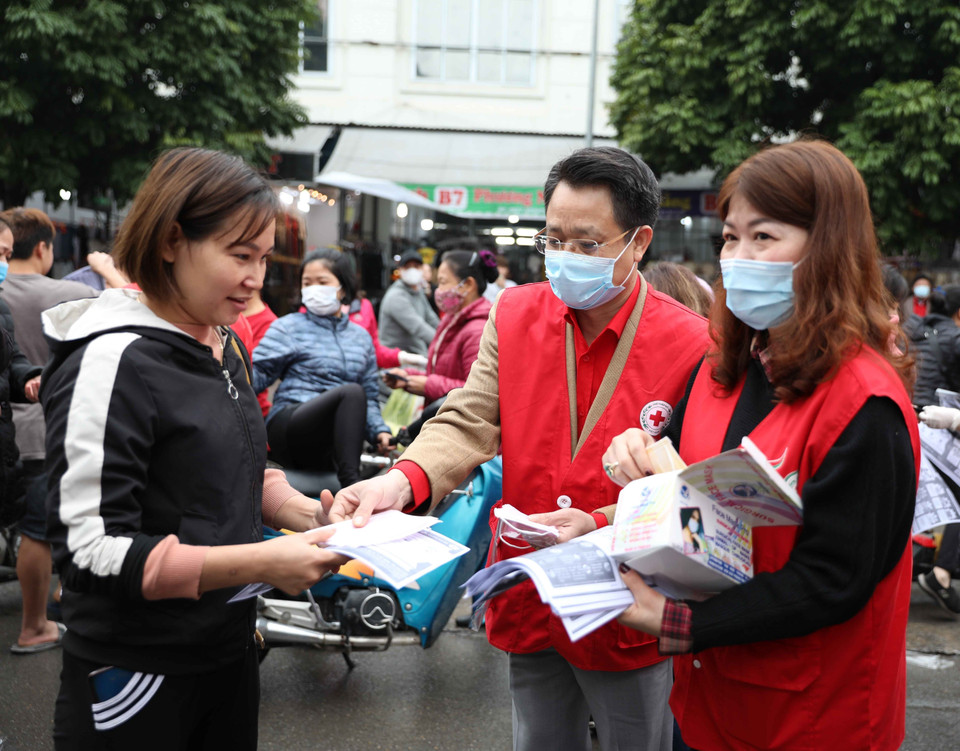 Chủ tịch Hội Chữ thập Đỏ thành phố Hà Nội Đào Ngọc Triệu tuyên truyền, phát khẩu trang cho người dân tại khu chợ Ninh Hiệp, Gia Lâm (Hà Nội). (Ảnh: Thanh Tùng/TTXVN)