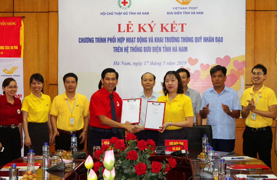 Đại diện Hội Chữ thập Đỏ và Bưu điện tỉnh Hà Nam ký kết Chương trình phối hợp hoạt động hưởng ứng Tháng nhân đạo 2019, đồng thời Khai trương thùng Quỹ Từ thiện tại các Bưu cục trong toàn tỉnh Hà Nam. (Ảnh: Đại Nghĩa/TTXVN)