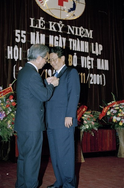 Chủ tịch Hội Chữ thập Đỏ Việt Nam, giáo sư Nguyễn Trọng Nhân gắn huy chương Vì sự nghiệp nhân đạo cho Chủ tịch nước Trần Đức Lương tại Lễ Kỷ niệm 53 năm Ngày thành lập Hội (2001). (Ảnh: Hữu Oai/TTXVN)