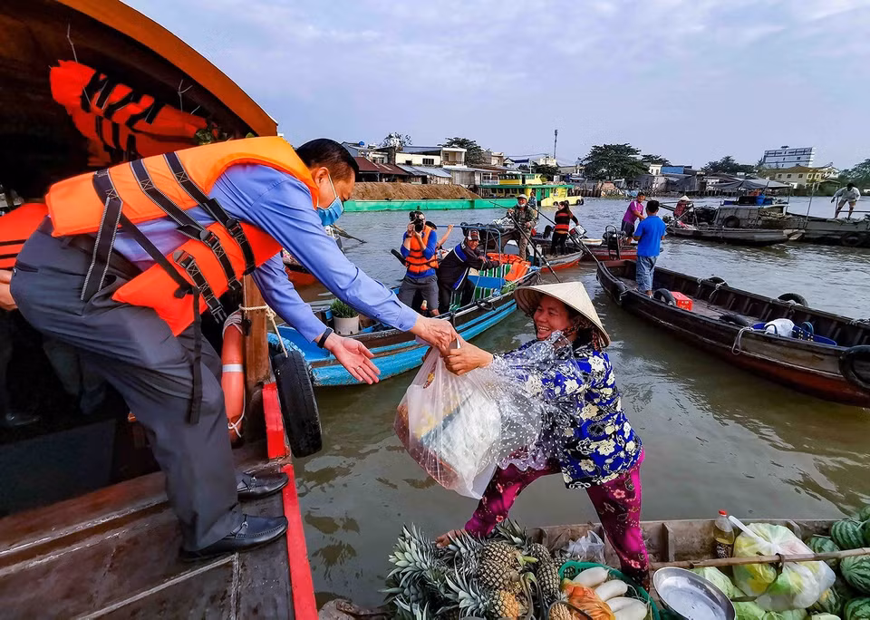 Lãnh đạo thành phố Cần Thơ thăm hỏi, tặng quà Tết cho tiểu thương trên chợ nổi Cái Răng trong dịp Tết Nguyên đán Canh Tý 2021. (Ảnh: Thanh Liêm/TTXVN)