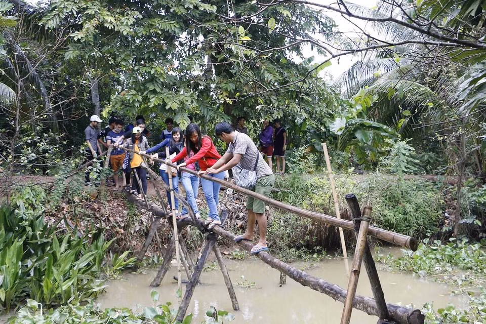 Với đặc điểm của một vùng đất trù phú, có nhiều diện tích đất phù sa, những vườn cây ăn trái phát triển tươi tốt, ngành du lịch Cần Thơ đã nắm bắt được những điều kiện thuận lợi để phát triển mô hình du lịch miệt vườn. Trong ảnh: Du khách trải nghiệm đi cầu khỉ ở Cồn Sơn, phường Bùi Hữu Nghĩa, quận Bình Thủy, thành phố Cần Thơ. (Ảnh: Thanh Liêm/TTXVN)