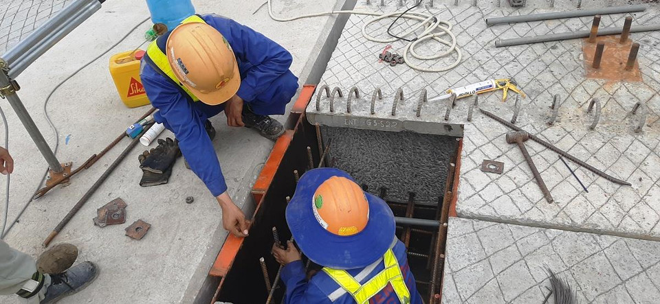 Công nhân tiến hành bắt ốc, đai bulông giữa phiến dầm nặng khoảng 70 tấn với hệ thống xà mũ của bệ trụ. (Ảnh: Việt Hùng/Vietnam+)