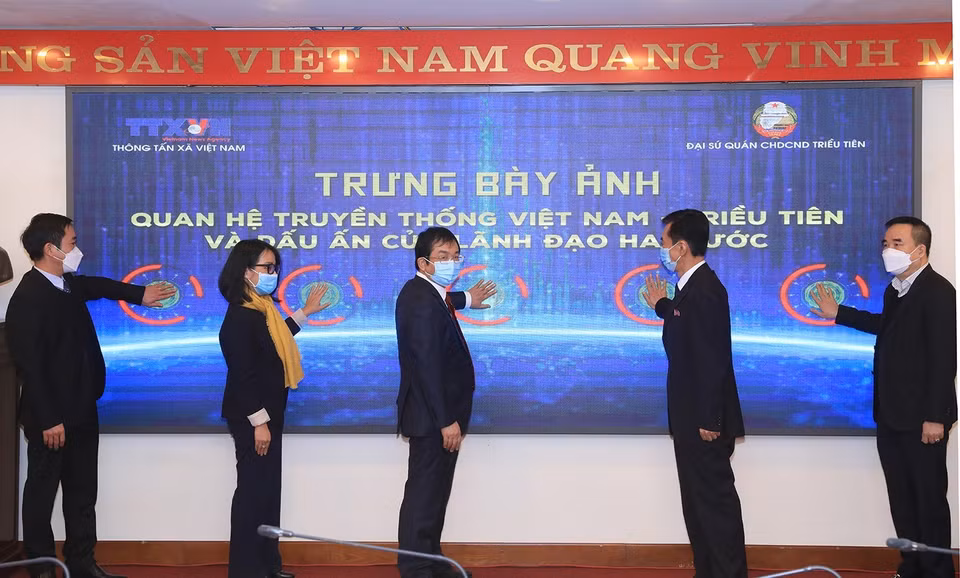 Phó Tổng giám đốc Thông tấn xã Việt Nam Nguyễn Tuấn Hùng và Tham tán, Đại biện lâm thời Đại sứ quán Cộng hòa dân chủ nhân dân Triều Tiên tại Việt Nam Ri Ho Jun cùng các đại biểu bấm nút khai mạc trưng bày ảnh. (Ảnh: Tuấn Anh/TTXVN)