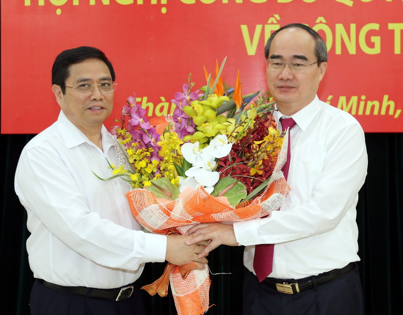 Đồng chí Phạm Minh Chính, Ủy viên Bộ Chính trị, Bí thư Trung ương Đảng, Trưởng ban Tổ chức Trung ương tặng hoa chúc mừng đồng chí Nguyễn Thiện Nhân. (Ảnh: Thanh Vũ/TTXVN)