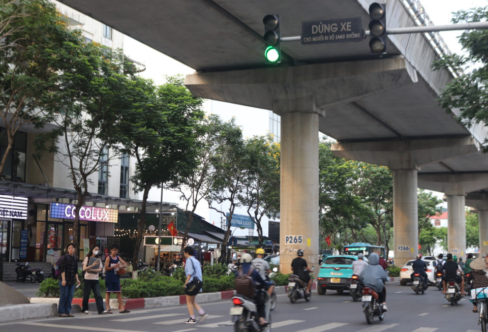 Trong khi người điều khiển xe máy vô tư vượt và không nhường cho người đi bộ sang đường. (Ảnh: Nguyễn Minh Hằng/Vietnam+)