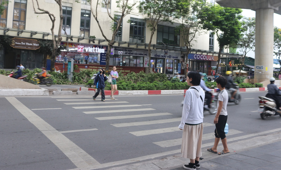 Dù đèn tín hiệu đã chuyển xanh cho phép người đi bộ sang đường nhưng vẫn phải chần chừ bởi lo ngại bị chủ xe vượt đèn đâm phải. (Ảnh: Nguyễn Minh Hằng/Vietnam+)