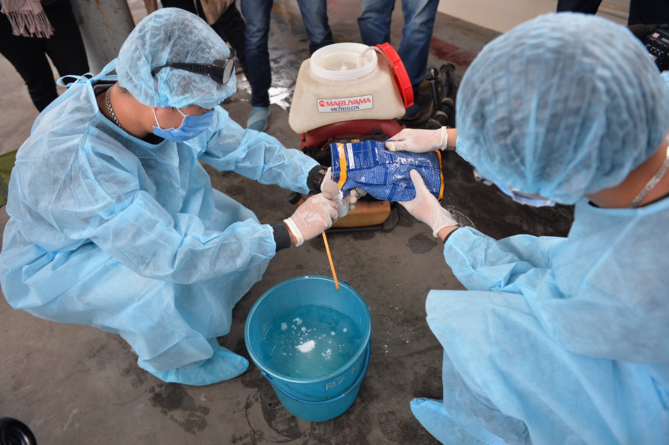 Các nhân viên của Trung tâm y tế dự phòng đường sắt tiến hành pha dung dịch phun thuốc khử trùng. (Ảnh: Việt Hùng/Vietnam+)