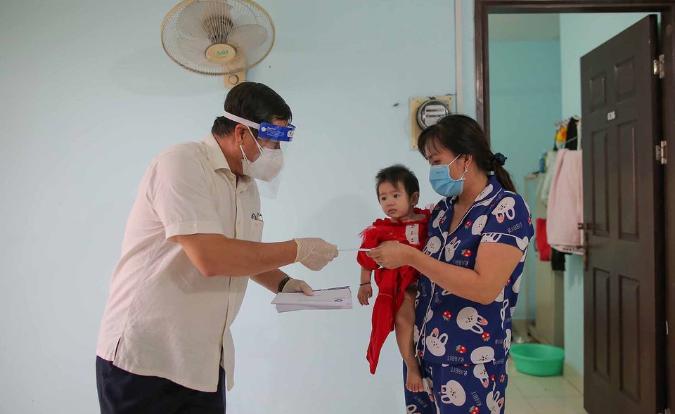 Đại diện Ban tổ chức trao tiền hỗ trợ cho người dân sau khi đế ở tại Nhà nghỉ Công đoàn Thanh Đa. (Ảnh: Thanh Vũ/TTXVN)