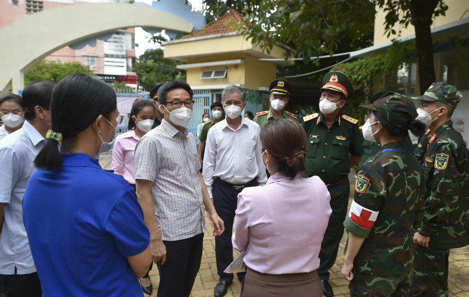 Phó Thủ tướng Vũ Đức Đam động viên lực lượng chức năng tham gia chống dịch trên địa bàn Quận 6.(Ảnh: TTXVN phát)