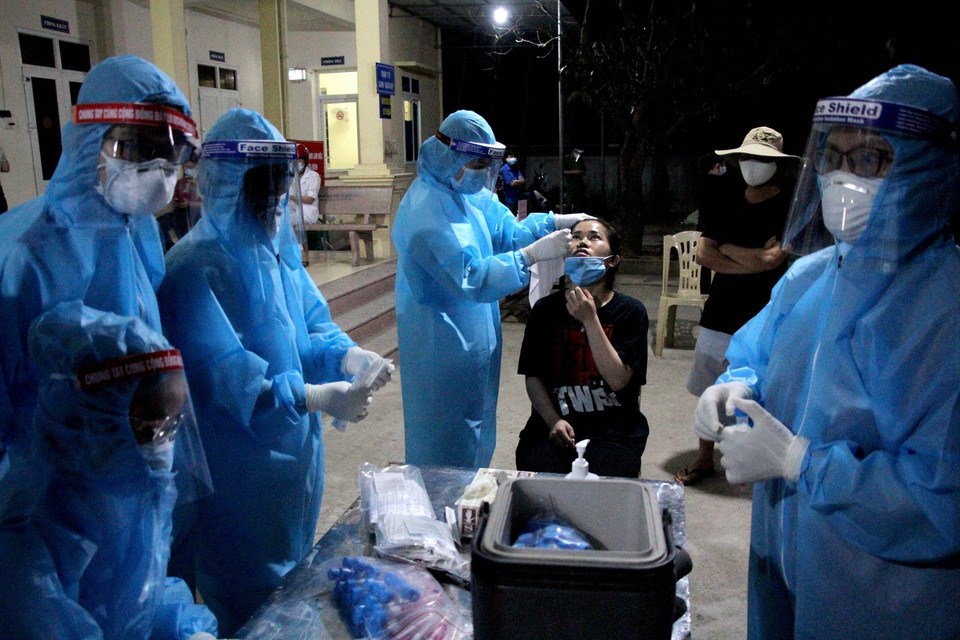 Lực lượng y bác sỹ xuyên đêm lấy mẫu xét nghiệm đối với các trường hợp là F1 của bệnh nhân số 11634 ở huyện Diễn Châu, Nghệ An. (Ảnh: Văn Tý/TTXVN)