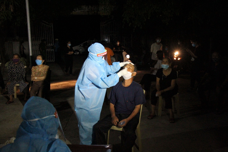 Lực lượng y bác sỹ xuyên đêm lấy mẫu xét nghiệm đối với các trường hợp là F1 của bệnh nhân số 11634 ở huyện Diễn Châu, Nghệ An. (Ảnh: Văn Tý/TTXVN)