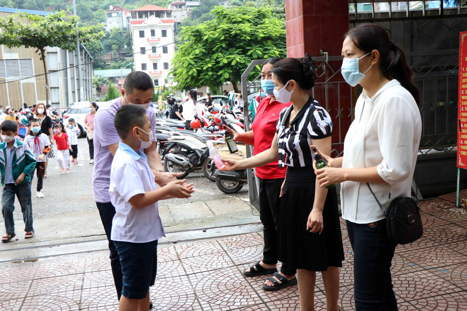 Các trường học thực hiện việc sát khuẩn tay cho học sinh, phụ huynh khi đến trường. (Ảnh: Hữu Quyết/TTXVN)
