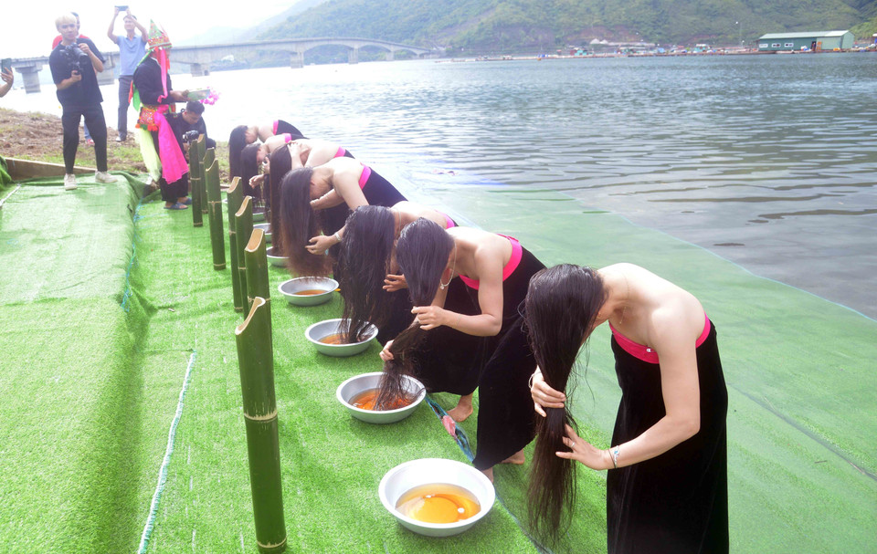 Các thí sinh của Cuộc thi Hoa hậu Du lịch Thế giới 2022 tái hiện nghi lễ gội đầu của người Thái Trắng, huyện Quỳnh Nhai. (Ảnh: Quang Quyết/TTXVN)