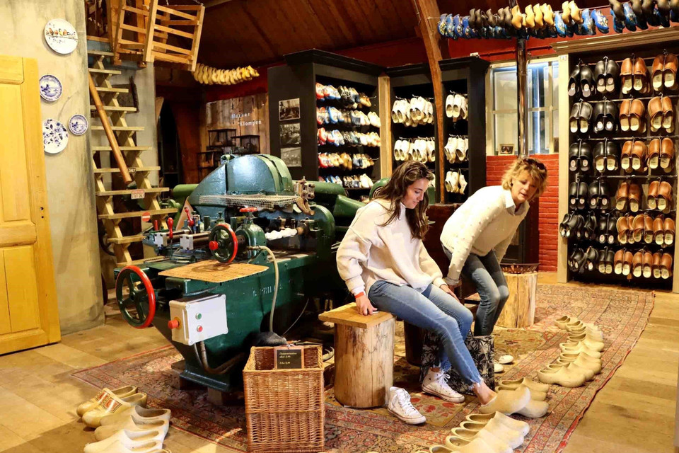 Du khách tham quan xưởng sản xuất guốc gỗ ở làng Marken. (Ảnh: Hương Giang/TTXVN)