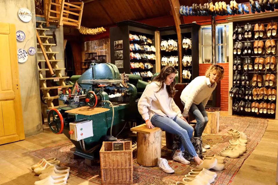 Du khách tham quan xưởng sản xuất guốc gỗ ở làng Marken. (Ảnh: Hương Giang/TTXVN)