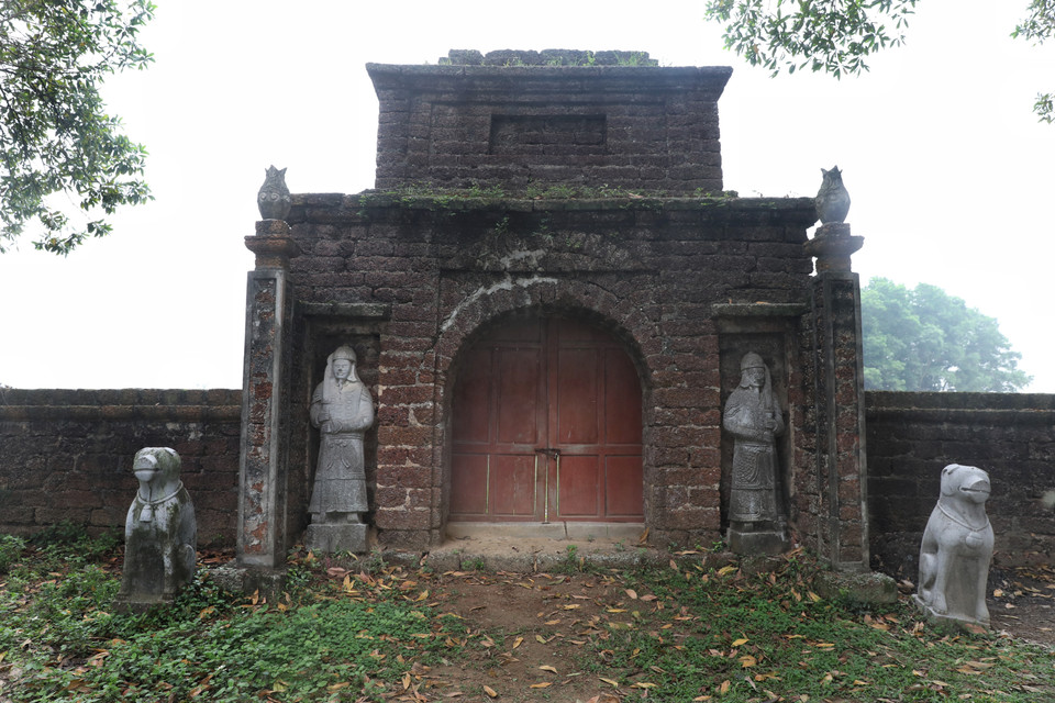 Cổng lăng đá Bầu gồm có 2 tầng, dưới là vòm cuốn được ghép bởi những phiến đá ong lớn. Bên cạnh cổng lăng, có 2 tượng võ sỹ, đứng nghiêm trang, mặc áo giáp, chân đi hia, tay nắm long đao. (Ảnh: Danh Lam/TTXVN)