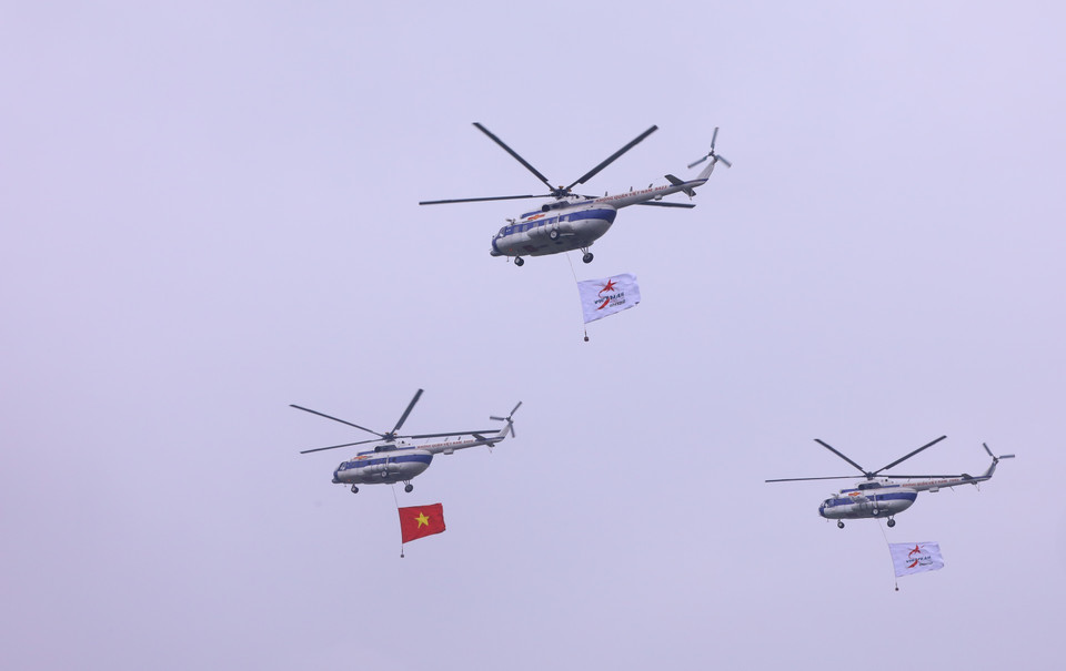 Biên đội trực thăng dòng Mi thuộc Trung đoàn không quân 916 cùng cờ Tổ quốc và cờ hiệu Triển lãm Quân sự quốc tế Việt Nam 2022 biểu diễn trên không gian triển lãm. (Ảnh: Văn Điệp/TTXVN)