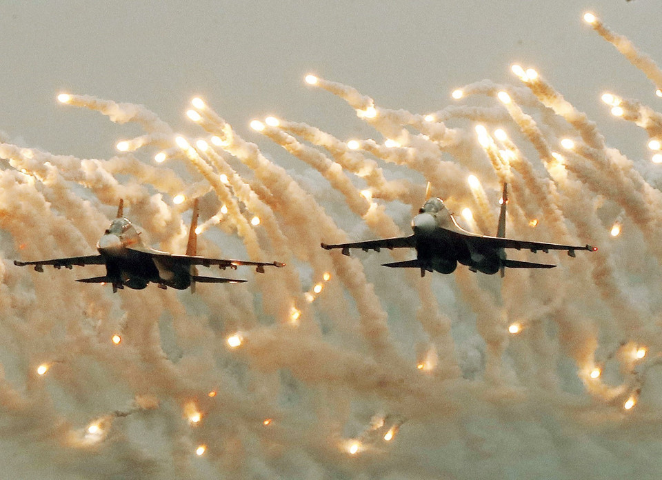 Hai chiếc Su-30MK2 trình diễn trong ngày khai mạc với màn bay nhả đạn mồi bẫy tên lửa trên bầu trời. (Ảnh: Lâm Khánh/TTXVN)