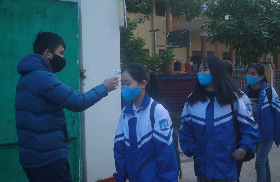 Học sinh Cao Bằng đo nhiệt độ thân nhiệt trước khi vào lớp học. (Ảnh: Chu Hiệu/TTXVN)