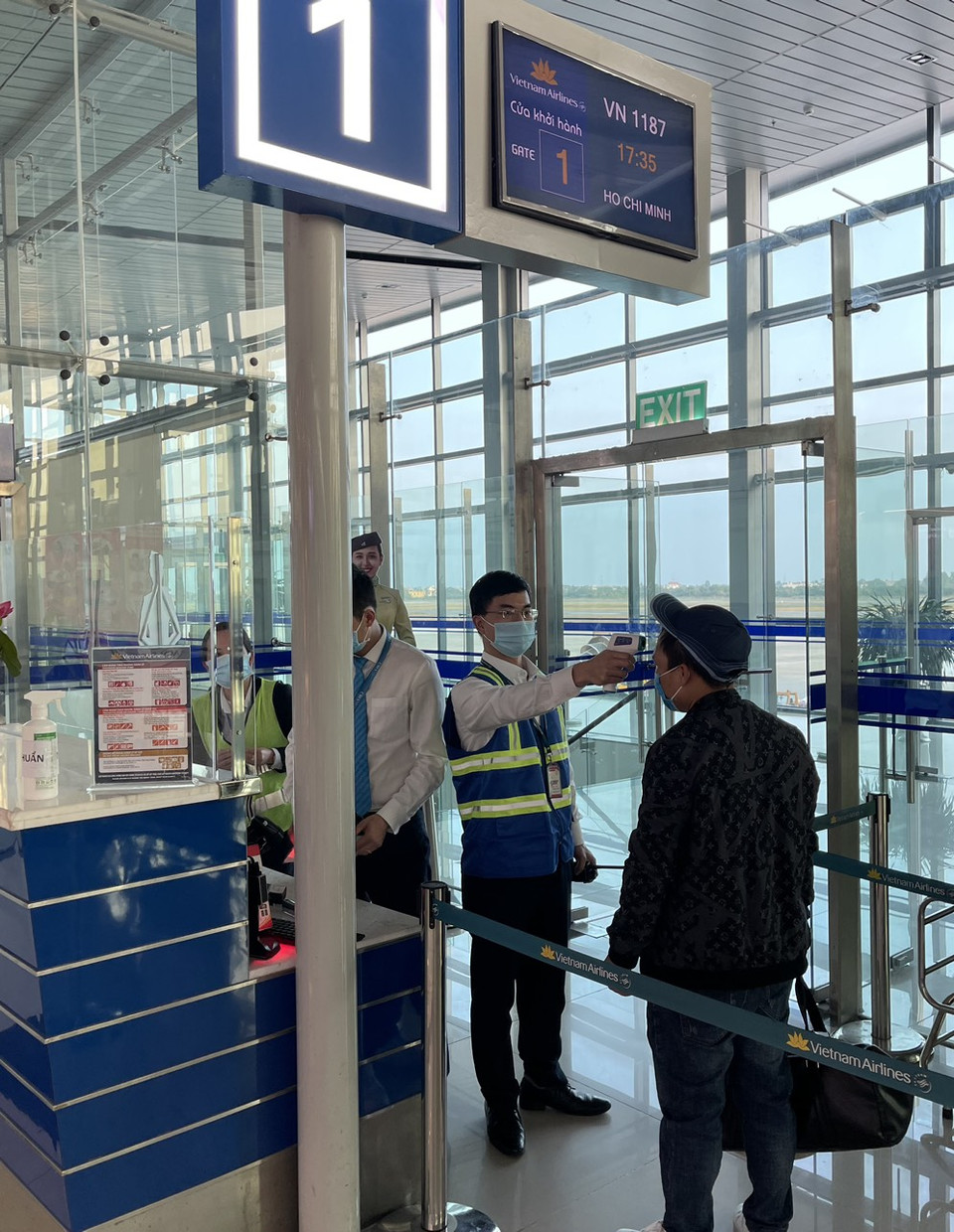 Hành khách Vietnam Airlines được đo thân nhiệt trước khi lên tàu. (Ảnh: CTV/Vietnam+)