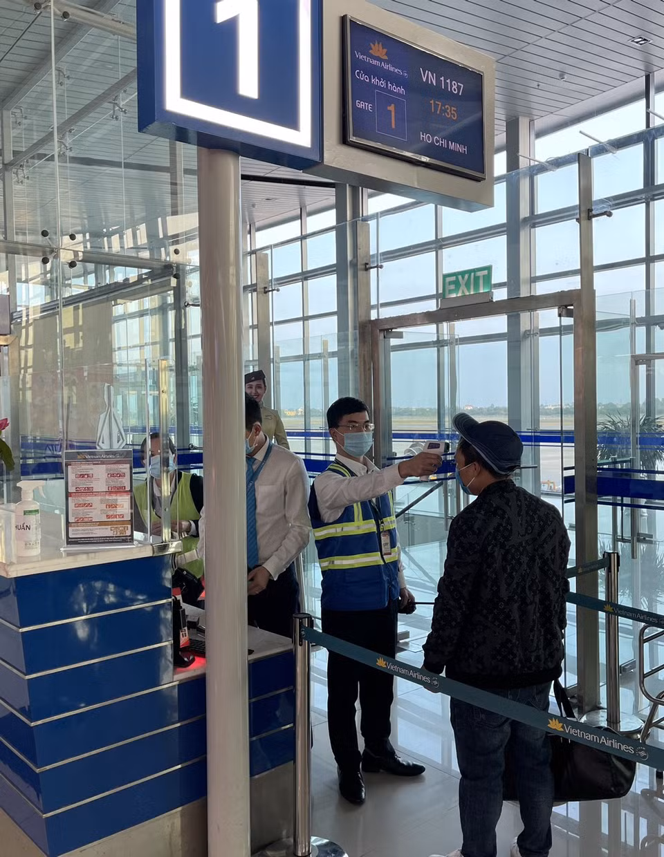 Hành khách Vietnam Airlines được đo thân nhiệt trước khi lên tàu. (Ảnh: CTV/Vietnam+)