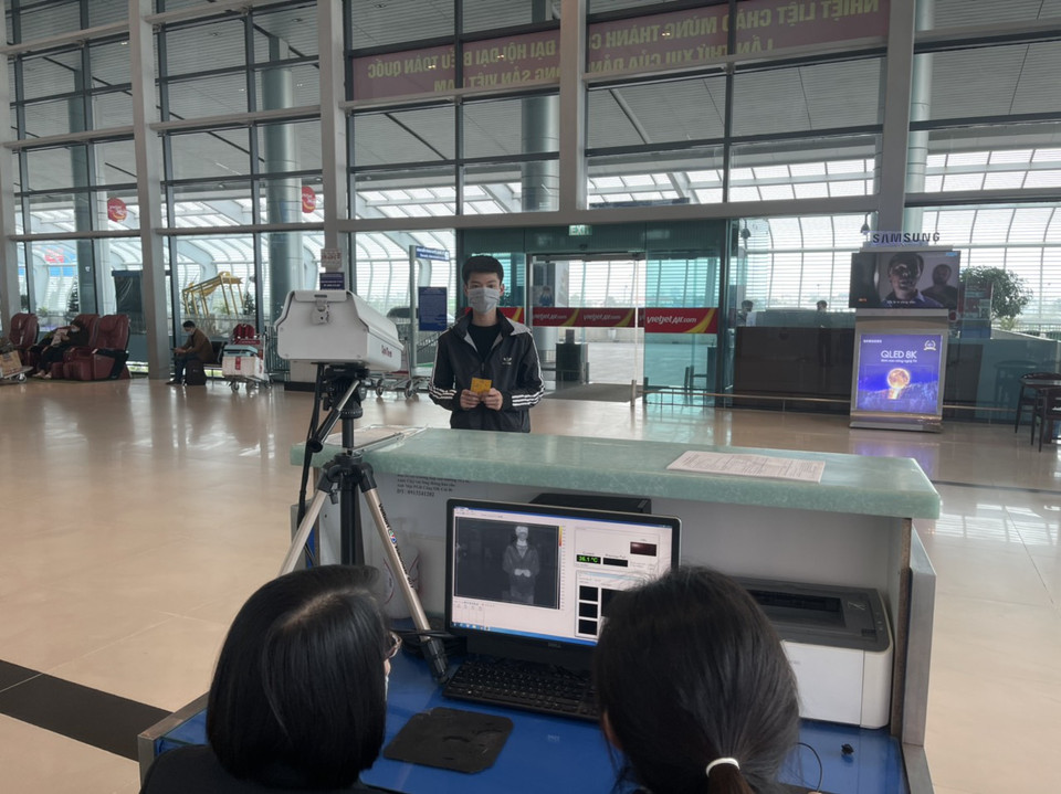 Nhà chức trách tại sân bay đo thân nhiệt hành khách tại cửa ra vào sân bay Cát Bi. (Ảnh: CTV/Vietnam+)