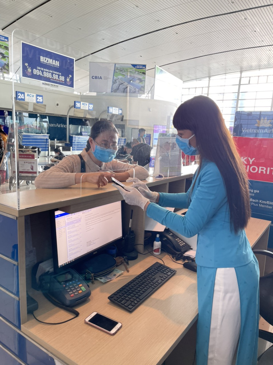 Nhân viên mặt đất của Vietnam Airlines hướng dẫn hành khách làm thủ tục. (Ảnh: CTV/Vietnam+)